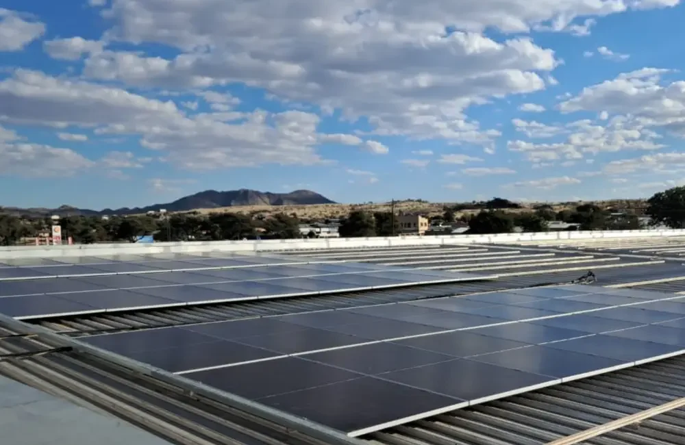 Commercial rooftop solar installation connected to the electricity grid in the UK under partly cloudy daytime conditions